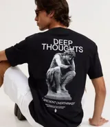 Remera negra de corte relajado con cuello redondo y manga corta. Presenta un pequeño estampado blanco en el pecho izquierdo con el texto "DEEP THOUGHTS" y un símbolo debajo.