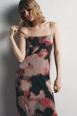 Vestido largo con estampado floral en tonos rosa, rojo y negro. Escote redondo con tirantes finos ajustables, espalda pronunciada y tira cruzada ajustable con lazada. Detalle de abalorios a contraste y forro interior.