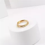 Set de dos anillos dorados de acero quirúrgico, entrelazados.