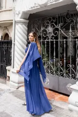 Vestido largo de fiesta color azul francia, con apliques de flores en la cintura y capa incluida.