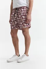 Short de baño estampado con cintura elástica, cordón ajustable, dos bolsillos laterales y uno trasero. Confeccionado en tela ligera de secado rápido y logo bordado.