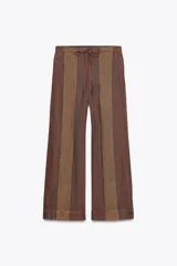 Pantalón de tiro medio confeccionado en hilatura de lino 100%. Cintura con elástico en espalda ajustable con cordones. Bolsillos laterales ocultos en costura y de plastrón en espalda.