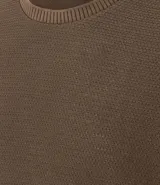 Remera de mangas cortas color crema, confeccionada con 50% algodón y 50% poliéster, con cuello redondo y tejido texturizado.