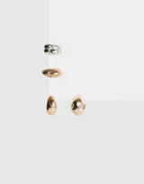 Set de aros dorados con forma de gota y earcuffs plateados.