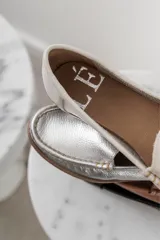 Mocasines de cuero color marrón claro con costuras a la vista.