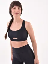Top deportivo negro con escote redondo y abertura en el centro del pecho.