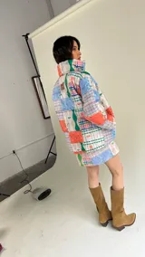 Campera puffer con estampado patchwork multicolor, cuello alto y bolsillos laterales.
