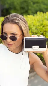 Billetera mediana marca Lincoln's confeccionada en cuero sintético con diseño bicolor. Presenta una tapa en tono dorado metalizado con cierre de presilla y cuerpo negro con compartimento de cremallera. Cuenta con múltiples divisiones internas para tarjetas, billetes y monedas, además de una práctica correa de mano.