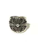 Anillo plateado con diseño de cruz gótica ornamentada con volutas. Fabricado en aleación con baño plateado, acabado envejecido y textura marcada.