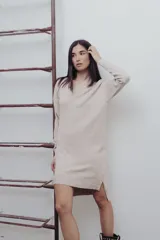 Vestido negro tejido con escote en V y corte recto. Largo hasta la rodilla con tajos laterales y detalle canalé en puños y ruedo.