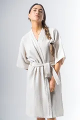 Bata kimono corta color beige, confeccionada en tela waffle de algodón. Tiene mangas al codo, lazo de ajuste en la cintura y detalle de vivo en la solapa.