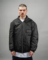 Campera reversible negra con estampado abstracto en rojo y blanco, de corte amplio y cuello camisero.