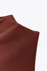 Musculosa marrón con cuello alto.