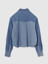 Camisa corta de jean celeste con dos bolsillos frontales con solapa y cierre con botones a presión.