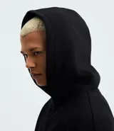 Buzo con capucha y bolsillo canguro delantero, color gris melange, de corte recto y holgado.