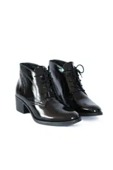 Botines acordonados de cuero charol negro, con tacón bloque y puntera ligeramente puntiaguda.