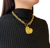 Collar dorado con cadena de eslabones gruesos y dije de corazón texturizado.