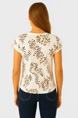 Remera marrón con estampado de ramas, corte holgado y mangas cortas.