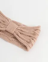 Vincha color beige de tejido de punto trenzado con detalle de lazo en el centro.