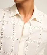 Camisa de manga corta color crema con textura cuadriculada con lesie, cuello inglés y abotonado delantero.