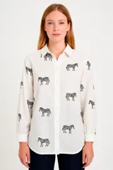 Camisa blanca con estampado de cebras negras, de corte holgado y manga larga.