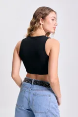 Musculosa corta negra de tejido de punto acanalado, con cuello redondo y sisas amplias.