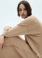 Vestido largo de punto color beige, con cuello redondo y mangas largas.