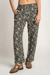 Pantalón recto con estampado de hojas color blanco sobre fondo negro, con cintura elástica y bolsillos laterales.