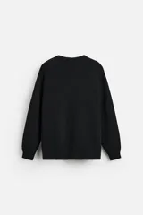 Sweater negro de punto con estructura de canalé, corte relaxed fit, cuello redondo y cierre de botones en el hombro.