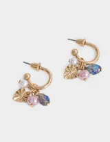 Aros argolla dorados con dijes de corazón y cuentas de vidrio de colores.