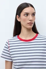 Remera de manga corta con rayas horizontales blancas y azul marino. Presenta cuello redondo con ribete rojo y costuras expuestas en rojo en los hombros.