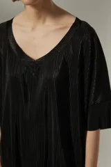 Blusa negra con cuello en V y mangas cortas, de tejido plisado.