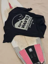 Camiseta negra de algodón con cuello redondo y calce holgado. Estampado en la espalda con una ola y el texto "Slow Waves Bells Beach Australia A Journey into the Waves".