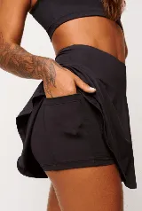 Pollera short deportiva negra con short interno y bolsillos laterales.