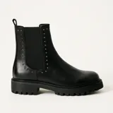 Bota de cuero negra con elástico lateral adornado con tachas y suela track.