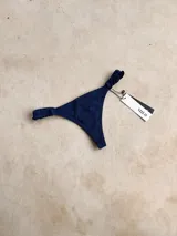 Bottom de bikini tipo colaless color azul con voladitos en los laterales y forro.