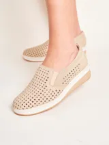 Panchita de cuero color beige con diseño calado, suela blanca y elástico en los laterales.