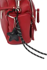 Bandolera color beige con correa ancha negra regulable y llavero de estrella.