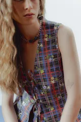 Chaleco tipo sastre con estampado a cuadros y flores, con escote en V y lazos para atar en la parte delantera.