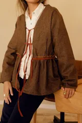 Chaqueta marrón de lana con forro de algodón y tiras de cuero. Diseño con cuello en V y corte a la cintura.