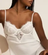 Camisón corto blanco de microfibra con breteles finos regulables y detalle de encaje floral en el busto.