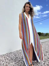 Vestido largo de tejido con diseño geométrico en tonos celeste, marrón, rojo y blanco. Tiene escote en V y aberturas laterales.