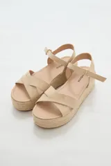 Sandalias color beige con plataforma de yute y tiras cruzadas sobre el empeine.