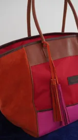Bolso de fin de semana tipo tote bag, confeccionado en lona y gamuza, con detalles en cuero color marrón. Tiene un bolsillo interno con cierre.
