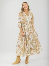 Vestido largo camisero con estampado floral en tonos rosados y blancos, con cuello camisero, manga 3/4 y falda escalonada. Incluye cinturón fino de soga.