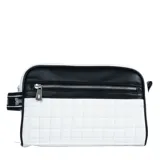 Neceser rectangular de cuero sintético blanco con diseño acolchado a cuadros y detalles en cuero sintético negro. Tiene cierre superior y frontal con tiradores metálicos plateados. Presenta una correa de mano con el logo de la marca.