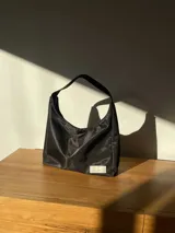 Cartera tipo baguette negra de lona semi impermeable con cierre metálico y forrería de gross con bolsillo interno.