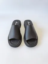 Sandalias negras de cuero con plataforma baja.