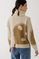 Sweater de punto color verde militar con cuello alto y bordados de hilo color mostaza.