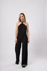 Mono largo negro de punto con escote halter y corte palazzo. Incluye un collar largo con dijes de estrellas plateadas.